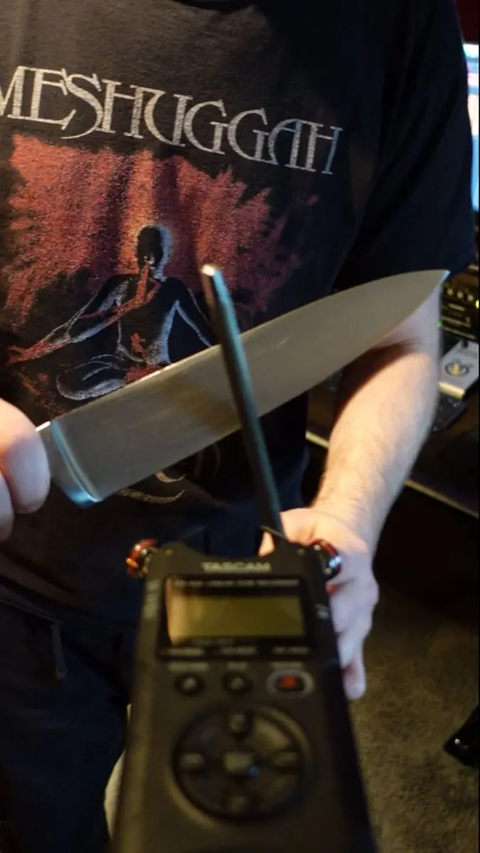Sharpening a chef's knife on a steel in front of a recorder