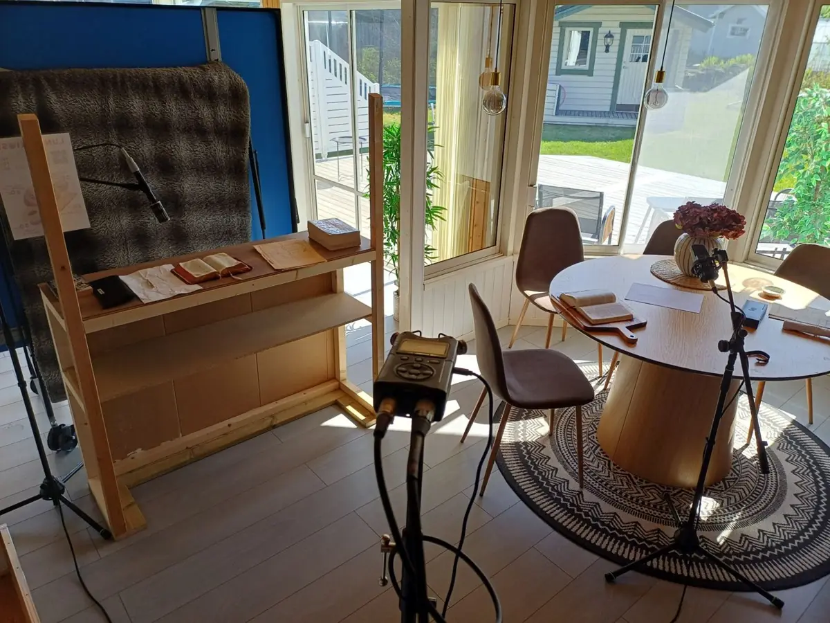 A library set with old books and microphones built in a sunlit room